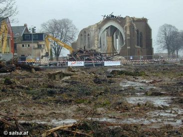 im Vordergrund: der verwüstete Friedhof, im Hintergrund: heute wird die Kirche abgerissen (anklicken zum Vergrößern)